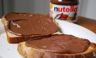 Un pot de pâte à tartiner Nutella et des tartines.