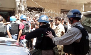 Photo fournie par Shaam News Network montrant les experts de l'ONU entourés par des combattants rebelles, des civils et des journalistes le 28 août 2013 à leur arrivée à Ghouta, l'un des sites de l'attaque chimique présumée