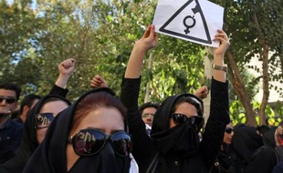 Des iraniennes, le visage caché pour ne pas être reconnues, crient des slogans lors d'une manifestation à Ispahan afin de demander des mesures de sécurité supplémentaires après des attaques à l'acide perpétrées contre des femmes, le 22 octobre 2014
