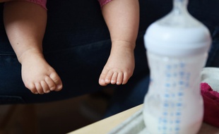 Illustration de pieds d'enfant et d'un biberon.