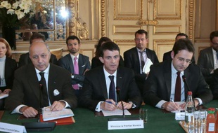 Le Premier ministre Manuel Valls (c) et le ministre des Affaires étrangères Laurent Fabius (g) lors d'une réunion avec des représentants de l'hôtellerie-restauration, des transports et des voyagistes à Paris, le 23 novembre 2015