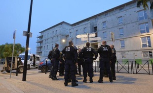 Des policiers montent la garde devant le commissariat de Trappes le 21 juillet 2013, après des affrontements entre la police et des habitants, suivant le contrôle d'identité de Cassandra Belin