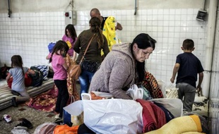 Des migrants des pays de l'Est s'installent temporairement dans un local à Décines-Charpieu après avoir séjourné dans des bâtiments de l'armée et du diocèse de Lyon, le 21 avril 2015