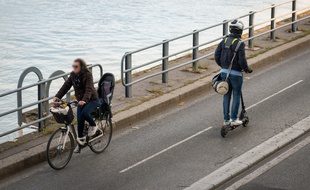 Une cycliste et un homme à trottinette circulent sur la piste cyclable de la voie Georges-Pompidou, à Paris (15e).