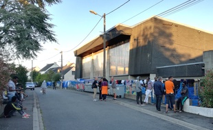 Des riverains discutent avec des migrants devant le gymnase Jeanne-Bernard où vivent près de 500 exilés.