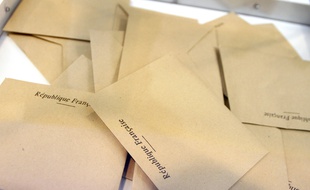 Des bulletins de vote ans une urne.