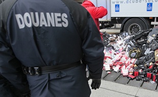 Un gendarme regarde, le 27 janvier 2011 à Paris, des articles de contrefacon avant leurs destructions.