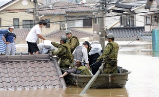 Les forces de défense japonaises aident les habitants de Kurashiki, dans la préfecture de Okayama, à évacuer leurs maisons après les pluies torrentielles qui se sont abattues dans la région le 7 juillet 2018.