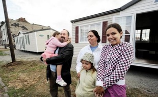 La famille Lenclud pose, le 19 août 2008, devant l'un des mobile-homes, destinés à reloger les sinistrés de la tornade qui a balayé plusieurs communes autour de Maubeuge (Nord) dans la nuit du 03 au 04, qui ont été installés ce jour à Hautmont, la commune la plus touchée. Ces mobile-homes sont installés au coeur d'un quartier populaire de la ville où des dizaines de logements ont été endommagés ou détruits par la tornade, qui a fait trois morts et dix-huit blessés.