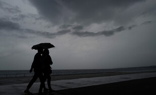 Des promeneurs sous la pluie.