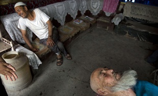 Un Ouïghour s'apprête à se faire masser la barbe dans un salon de la province chinoise du Xinjiang, le 17 juillet 2014.