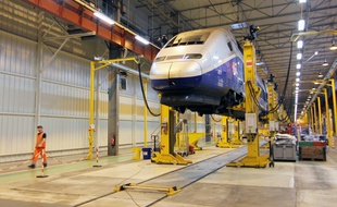 Un salarié de PSA marche le long d'un TGV en suspension au sein de l'usine de La Janais, près de Rennes. Le site a rénové les rames de TGV de 2014 à 2017.