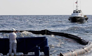Des ouvriers tentent, le 27 avril 2010, d'endiguer la nappe de pétrole qui s'échappe après l'explosition de la plateforme pétrolière Deepwater dans le golfe du Mexique.