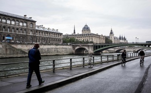 Un homme marche sur les berges de Seine rive-droite.