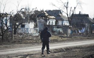 Un homme marche dans une rue détruite de Nikichiné, dans l'est de l'Ukraine, le 11 mars 2015