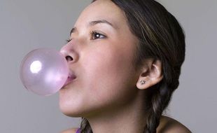 Une jeune fille en train de faire une bulle avec son chewing-gum