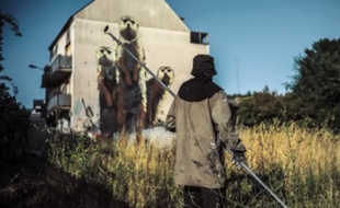 Le graffeur War devant sa dernière œuvre à Rennes.