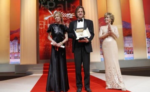 Les producteurs Bill Pohlad et Dede Gardner recevant des mains de l'actrice Jane Fonda (à droite) la Palme d'Or du 64e Festival de Cannes remise à «The Tree of Life». Le réalisateur Terrence Malick, maladivement timide, n'est pas venu la chercher. Cannes, le 22 mai 2011