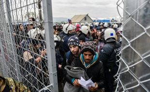 Des migrants attendent à la frontière entre la Grèce et la Macédoine près de la ville de Gevgelija le 4 décembre 2015