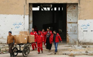 Des membres du Croissant Rouge passent d'un quartier d'Alep contrôlé par le régime syrien à une zone aux mains des rebelles, pour distribuer l'aide humanitaire aux écoliers, le 21 février 2015