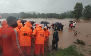Des membres de la National Disaster Response Force viennent en aide à des personnes prises par les eaux après un glissement de terrain à Chiplun, dans l'ouest de l'Inde, le 23 juillet 2021.