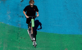 Un usager sur une trottinette Lime à Paris, le 9 juillet 2018.