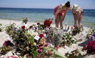 Des touristes déposent des gerbes sur le site de l'attaque sur la plage de Sousse le 30 juin 2015