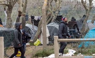 Des migrants marchent près de leur camp à Calais, le 23 octobre 2014.
