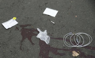 "Vos guerres, nos morts" écrit sur des morceaux de papiers sur le pavé ensanglanté le 14 novembre 2015 près du Bataclan à Paris