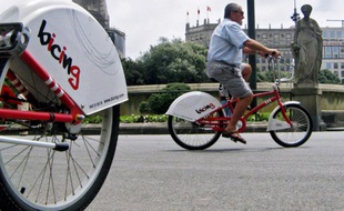 Un homme fait du vélo en libre-service à Barcelone, le 18 juin 2007