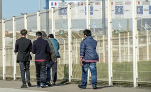 Des migrants passent près du terminal des ferries à Calais le 5 août 2014
