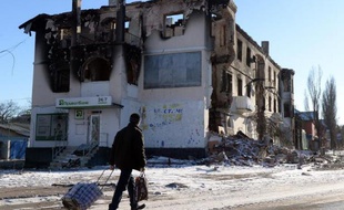 Un homme passe le 18 février 2015 devant un immeuble de la ville de Uglegorsk, près de Debaltseve, dans la la région de Donetsk