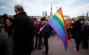 Un homme porte un drapeau arc-en-ciel, emblème de la communauté LGBT, lors d'une manifestation contre l'homophobie à Rouen en 2018 (illustration)