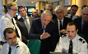 Jean-Marc Ayrault (C), entouré par Manuel Valls (G) et Philippe Martin (D), à la préfecture de police de Paris le 17 mars 2014