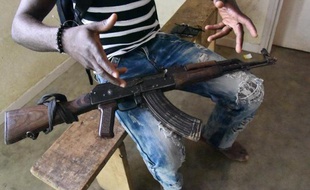 Un ancien combattant qui s'était battu pour Alassane Ouattara remet sa kalachnikov lors d'une opération de désarmement, le 22 avril 2015 à Yopougon, en Côte d'Ivoire