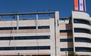 Un drapeau israélien recouvre le logo d'Orange, sur un bâtiment du groupe de télécoms israélien Partner, à Rosh Haain, près de Tel Aviv, le 11 juin 2015