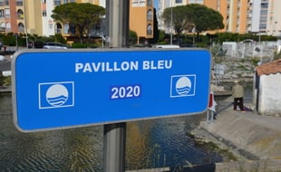 Un panneau indiquant que la commune est labellisée Pavillon bleu, à Carnon (Hérault)