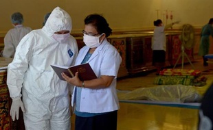 Des médecins légistes thaïs et laotiens établissent la liste des victimes d'un accident d'avion, le 19 octobre 2013 à Paksé, au Laos