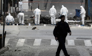 Des policiers sont sur le lieu de l'attentat perpétré près de la Banque de Grèce à Athènes, le 10 avril 2014.