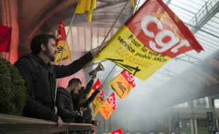 Un manifestant agitant un drapeau de la CGT lors d'une grève à la SNCF, le 26 avril 2016 à la Gare de Lyon à Paris.