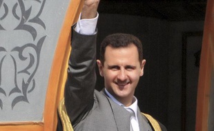 Le président syrien Bachar al-Assad salue la foule lors d'une visite dans al ville d'Ar-Raqqa, en Syrie, le 6 novembre 2011.