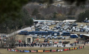 Les familles des victimes arrivent dans le village du Vernet, non loin du site du crash de l'A320 de Germanwings, alors que des secouristes ont déployé les drapeaux des nationalités des passagers, le 26 mars 2015