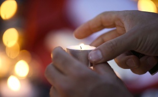 Un homme allume une bougie en hommage aux victimes de l'attentat de Nice, le 15 juillet 2016.