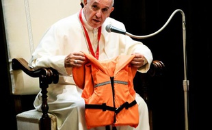 Le pape François montre lors d'une réunion avec des jeunes, le 28 mai 2016 au Vatican, le gilet de sauvetage d'un jeune qui s'est noyé en Méditerranée en essayant de rejoindre l'Europe