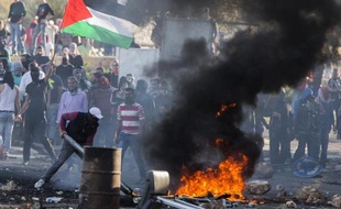 Des Arabes israéliens, certains arborant le drapeau palestinien, affrontent les forces de l'ordres à Kafr Kanna, en Israël, le 9 novembre 2014
