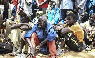 Des habitants écoutent le président malien Ibrahim Boubacar Keïta à Ogossagou, où 160 villageois peuls ont été tués, le 25 mars 2019.