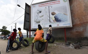 Des enfants regardent une affiche le 24 août 2014 mettant en garde contre le virus Ebola, à Abidjan