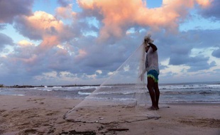 Un pêcheur palestinien prépare son filet avant de partir à la recherche de poisson sur la plage de Gaza, le 10 août 2014