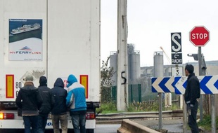 Des migrants attendent à l'arrière d'un camion non loin de la ville de Calais le 24 octobre 2014