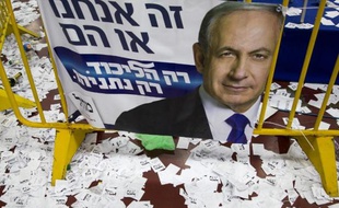 Des bulletins de vote autour d'une affiche de campagne du Premier ministre sortant et candidat du Likoud aux législatives israéliennes Benjamin Netanyahu, le 18 mars 2015 à Tel-Aviv